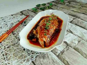 鱼熟，汁浓，装入盘中，撒上熟白芝麻，葱花点缀。