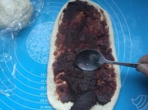 擀成长的椭圆形，机上豆沙馅，用小勺子铺平。