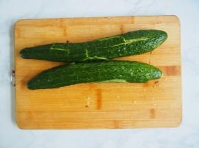 将黄瓜洗净，用刀拍扁