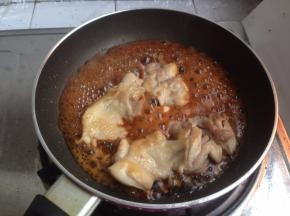 锅里放入鸡肉调料：酱油、料酒、糖和姜末，煮沸后加入煎好的鸡腿肉。两面轮流翻动，煮至酱汁收干