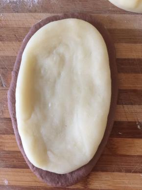 发好的面团 分两份 滚圆松弛十分钟 擀开成梭形 麻薯同样分两份 擀开铺在面团上