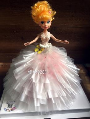 娃娃包上保鲜膜，插进娃娃，继续粘贴上部分，在裙子和娃娃的衔接位置，用糖霜粘些糖珠来挡一下衔接位置