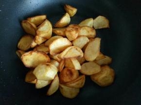 炸好的土豆放入锅中。