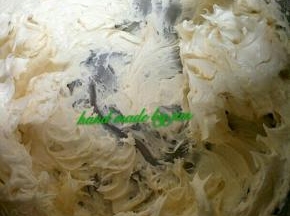 分次加入糖粉和加热的淡奶油到黄油里进行打发