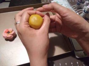 将剩余的皮料（20克左右）包住20克豆沙馅儿，用虎口慢慢收，直到包拢。（粉色忘记拍照了，拿这个做实例吧，哈哈）