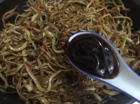 8. 翻炒至面条鱼开始变黄时加入蚝油