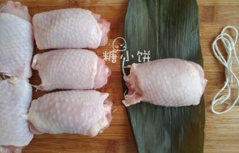 取一张粽叶把一个鸡腿卷包裹起来