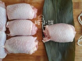取一张粽叶把一个鸡腿卷包裹起来