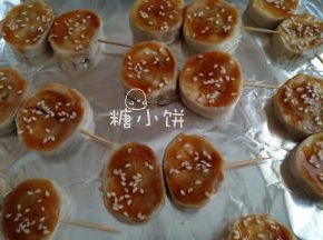 将蚝油1汤匙和香油1汤匙搅匀调成料汁，刷在鸡腿卷上，表面撒上芝麻