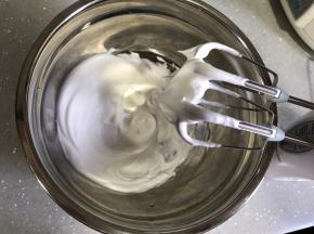 煮糖浆期间打发蛋白。开动电动打蛋器低速，将蛋清打发至细腻泡沫状，加入一半细砂糖，转高速打发至出现纹路，加入剩余细砂糖，高速打发至硬性发泡。