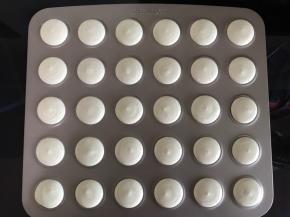 将面糊倒入套了中号圆形裱花嘴的裱花袋中，均匀的挤到马卡龙烤盘上。也可以用马卡龙硅胶烤垫或者高温油布，注意间距。