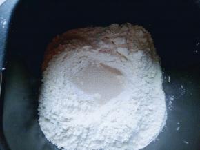 除黄油外的食材全放入面包桶，以先液体 后粉类么顺序放入。最后再面粉的顶端挖个小洞，放入酵母粉，(注意不要挖到液体)再用面粉把酵母粉盖起来。