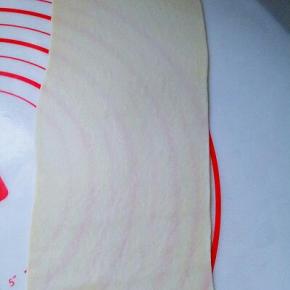 取一块面团用擀面杖擀长舌状。