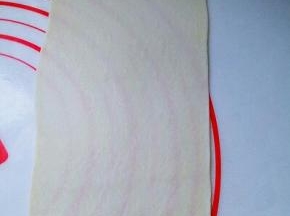 取一块面团用擀面杖擀长舌状。