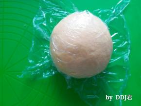 取出发酵好的面团，用手进行按压排气，排完气后的面团，覆盖保鲜膜，松弛15分钟