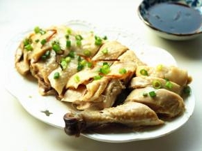 鸡身上撒上小葱碎，蘸着料汁食用。