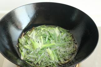 小葱切段。炒锅里放入适量的花生油，加入一部分芝麻油，熬出的葱油会更香。