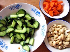 将黄瓜、胡萝卜切丁备用，腰果用水冲泡一下，沥干水分。