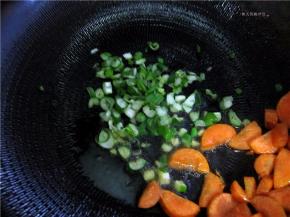 将胡萝卜拔拉到锅边，放入葱姜碎。