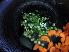 将胡萝卜拔拉到锅边，放入葱姜碎。