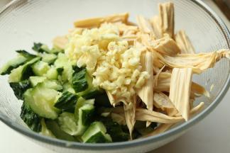 黄瓜和腐竹放入容器，蒜切末也放进去。