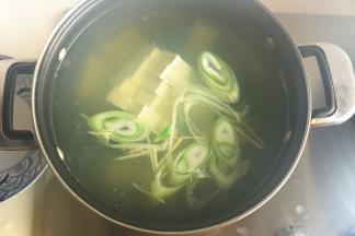 汤锅加速适量水，下入葱丝姜片和豆腐块，煮20分钟。