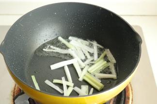 炒锅放油，爆香葱段。