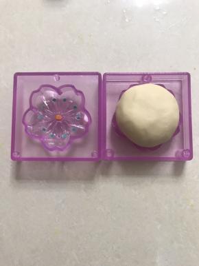 取一份牛好味桃山皮包上馅料，在另外一种花型上涂上绿色桃山皮，中间用桔黄色的，以下方法同上脱模