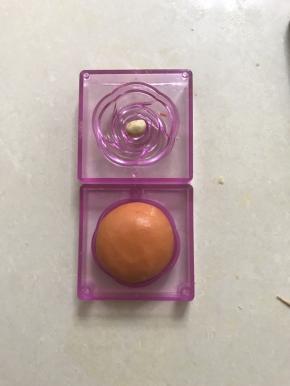 再取一种模柜，中间放上牛奶味桃山皮小圆球，合上模柜压紧脱模，以次做好八个桃山皮和果子月饼。