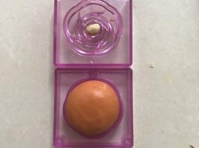 再取一种模柜，中间放上牛奶味桃山皮小圆球，合上模柜压紧脱模，以次做好八个桃山皮和果子月饼。
