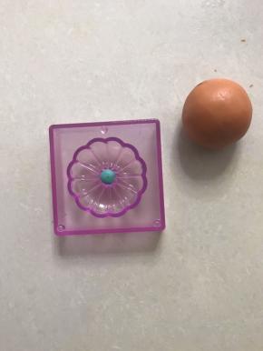 取一套模具，在上盖花型中间放上一个绿色小圆球