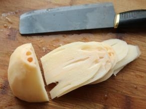 藕段立起来，顺着孔洞先切成薄片。