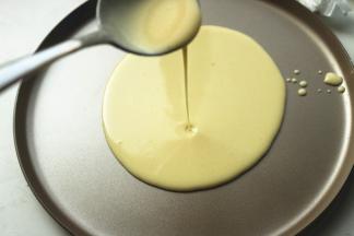 班戟锅放在炉子上，从最中间注入适量面糊，慢慢会摊满整个锅底。