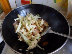 在加入花菜不停的翻炒