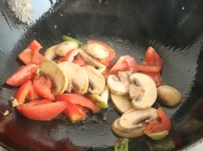 放入口蘑和西红柿翻炒。