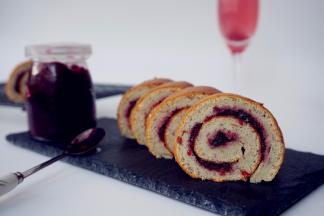 烘烤结束，将蛋糕取出，倒扣在烤架上，撕掉油布，在蛋糕表面涂上杨梅酱，卷起即可。