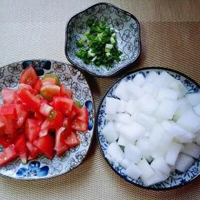 去皮的番茄切小块，冬瓜去皮，去瓤，洗干净切小块。葱切碎。