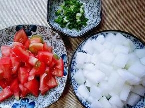 去皮的番茄切小块，冬瓜去皮，去瓤，洗干净切小块。葱切碎。