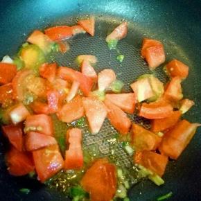 锅中加入油，加入葱花，再加入番茄煸炒。