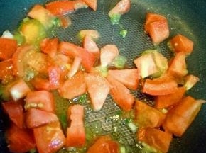 锅中加入油，加入葱花，再加入番茄煸炒。