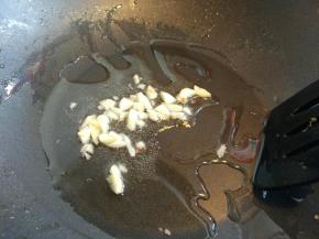 大蒜用刀面平着压扁，切碎，放入热锅热油中爆香