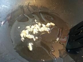 大蒜用刀面平着压扁，切碎，放入热锅热油中爆香