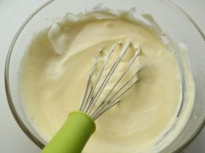 挖一勺蛋白到蛋黄糊里，用手抽拌匀。