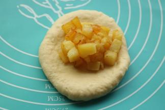 取一个面团，擀开成片状，挖一些土豆粒在上面。