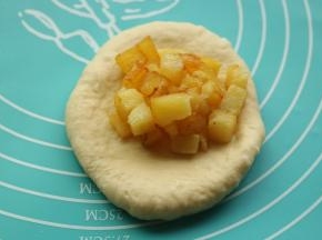 取一个面团，擀开成片状，挖一些土豆粒在上面。