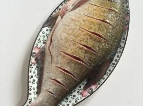 武昌鱼刮去鱼鳞片，去掉内脏，清洗干净后，鱼身子划斜刀，均匀涂抹一层盐腌制30分钟备用！
