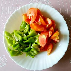 西红柿和青椒分别切成滚刀块备用。