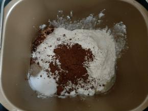 面包机中先放入全蛋液和牛奶，盐和糖对角放，再放入高粉和可可粉。