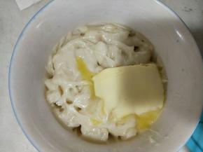 待麻薯稍微冷却一会后，趁热揉入黄油。用保鲜膜包好。