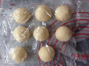 面团取出，排气，分成8等份，滚圆，盖上保鲜膜，静置15分钟